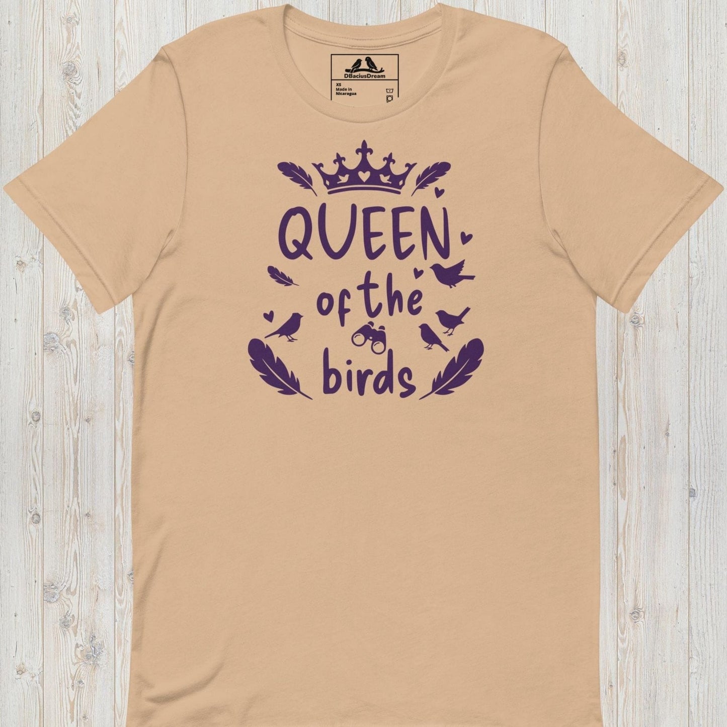 Beige queen of the birds t-shirt with a purple bird graphic, crown design and decorative bird silhouettes
